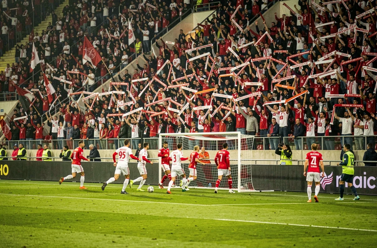 Stade comble lors d'une demi-finale de Coupe de France avec supporters et joueurs sur la pelouse du domicile